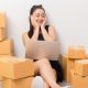 Kobieta między pudełkami - Jak zachęcić klientki do ponownych zakupów kosmetyków przez internet