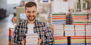 Mężczyzna z zeszytami. Czy miejsce papieru w gospodarce jest zagrożone? FB