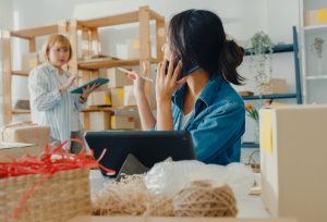 Właścicielka sklepu rozmawia przez telefon. Jak wyróżnić się w branży e-commerce - sprawdzone sposoby