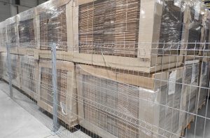 Palety z tekturą falistą w magazynie. Zalety tektury falistej — dlaczego warto ją stosować