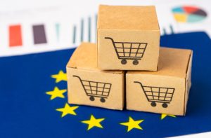 Trzy pudełka z tektury na fladze Unii Europejskiej. Zmiany legislacyjne dotyczące opakowań
