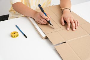Projektant tworzy prototyp pudełka z tektury. Jak projektować atrakcyjne opakowania z tektury .