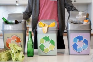 Mężczyzna z pojemnikami na odpady do recyklingu